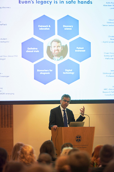 Prof Chandran at a lectern delivering the public lecture on MND research