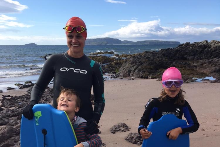 Picture of Laura Weir in wetsuit and swimming cap against backdrop of water
