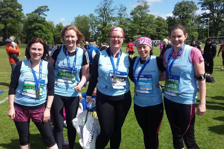 Five fundraising runners are wearing Euan MacDonald t-shirts and participation medals after completing a challenge, they're all smiling at the camera
