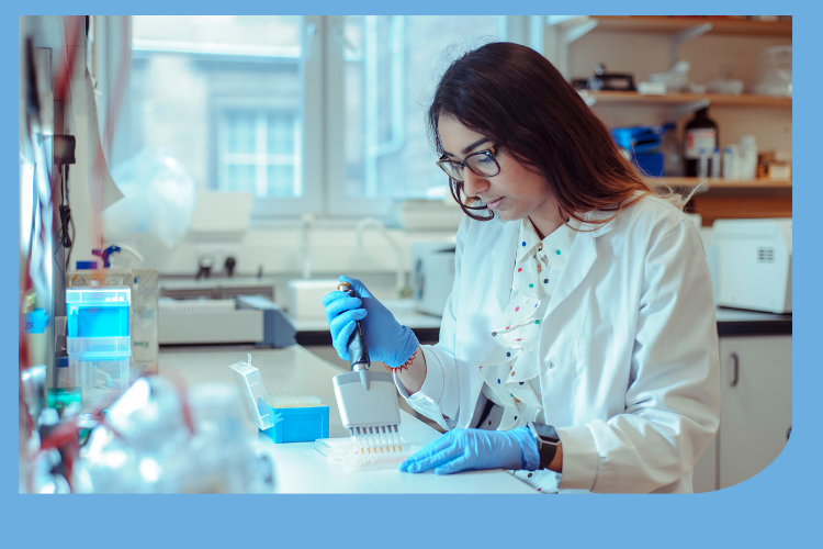 A female researcher wearing a lab coat, pipetting at a lab bench.