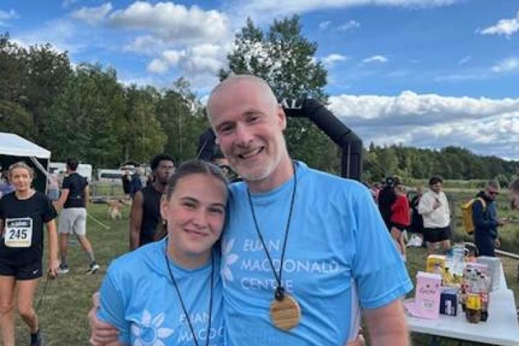 Megan and Tim Campbell after finishing the Six Lakes Marathon, both are wearing Euan MacDonald Centre t-shirts and finishers' medals