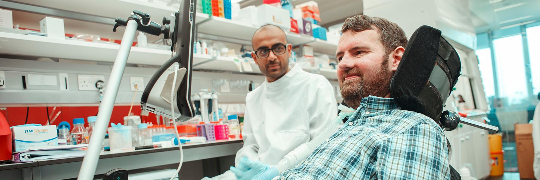 Euan MacDonald and a researcher in a lab