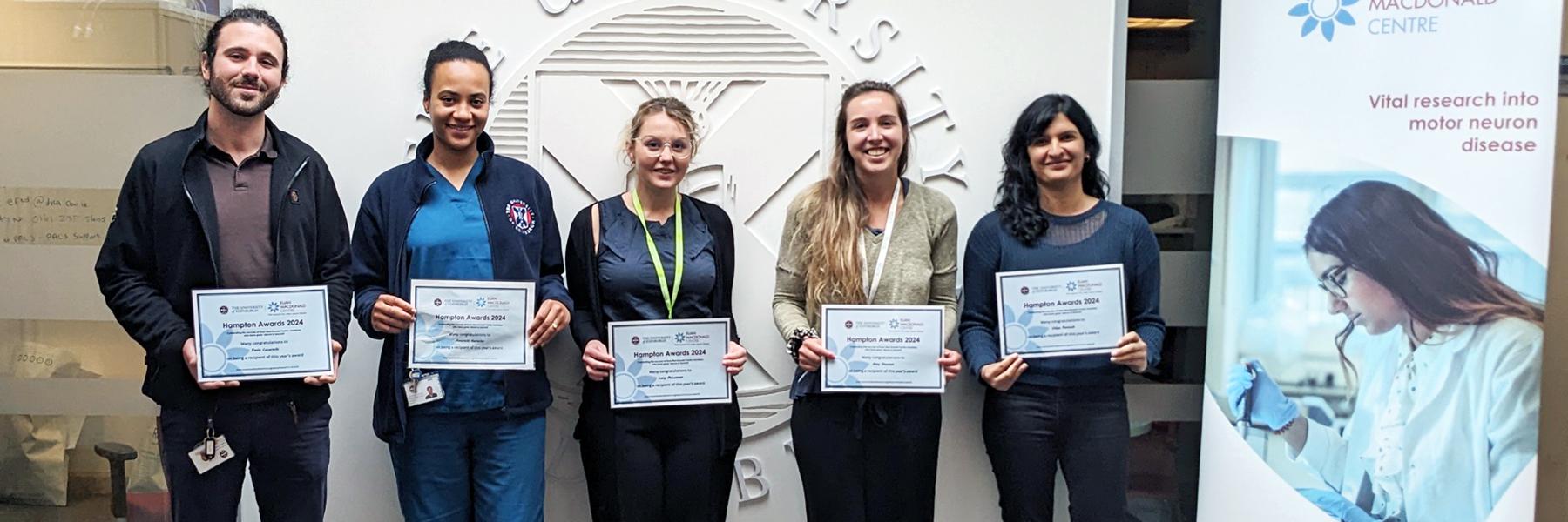Hampton Award winners 2018: five people standing and smiling, next to a Euan MacDonald Centre banner