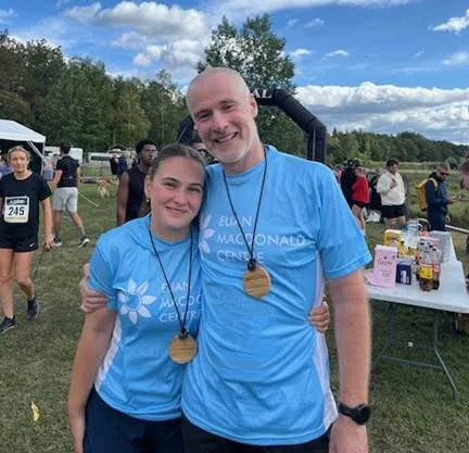 Megan and Tim Campbell after finishing the Six Lakes Marathon, both are wearing Euan MacDonald Centre t-shirts and finishers' medals